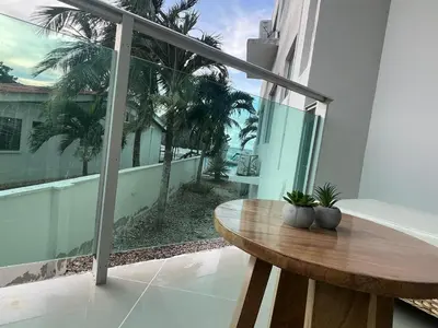 a balcony with a wooden table and a view of the ocean at Hermoso Apartamento Frente al Mar 2 Habitaciones B12B in Coveñas