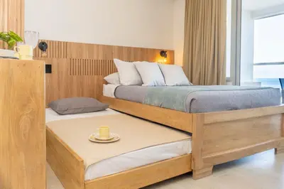 a bedroom with two beds and a cup of coffee on a platform at CB1004 Nueva Suite Frente al Mar - 2min Aeropuerto in Cartagena de Indias