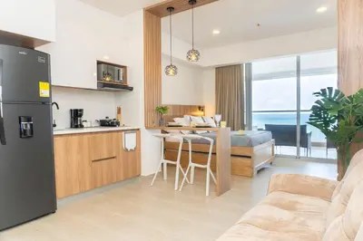 a kitchen and living room with a table and a couch at CB1004 Nueva Suite Frente al Mar - 2min Aeropuerto in Cartagena de Indias