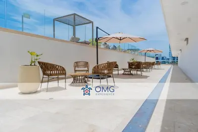 a patio with chairs and tables on a building at Cómoda Suite con Dos Camas Queen Piscina CB1031 in Cartagena de Indias