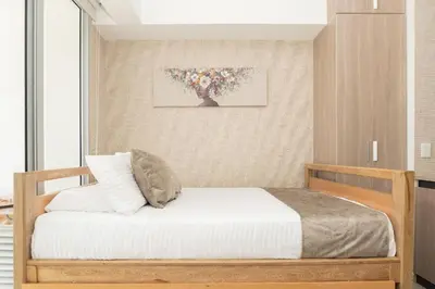 a small bedroom with a bed with white sheets at Cómoda Suite con Dos Camas Queen Piscina CB1031 in Cartagena de Indias