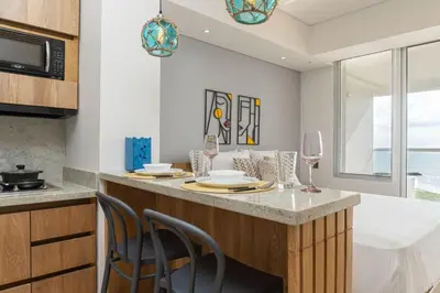a kitchen with a counter with chairs and a table with wine glasses at CB1204 | Suite minimalista frente al mar y atardeceres in Cartagena de Indias