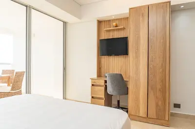 a bedroom with a bed and a desk and a tv at CB1204 | Suite minimalista frente al mar y atardeceres in Cartagena de Indias