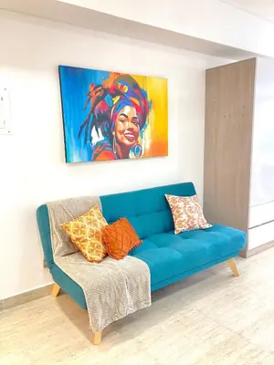 a blue couch in a living room with a painting at Estilo caribeño con vista al aeropuerto y cerca del mar CB1333 in Cartagena de Indias