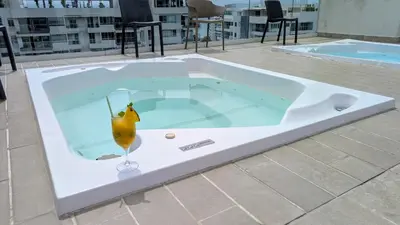 a jacuzzi tub with a drink in it at Piscinas con vista increible, bar, música y playa in Cartagena de Indias