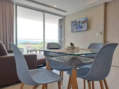 a dining room with a table and chairs and a living room at Piscinas con vista increible, bar, música y playa in Cartagena de Indias