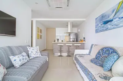 a living room with a couch and a kitchen at Descanso y playa, cómodo apartamento en Kuali, Santa Marta in Santa Marta