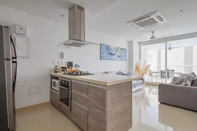 a kitchen with a stove and a refrigerator at Descanso y playa, cómodo apartamento en Kuali, Santa Marta in Santa Marta