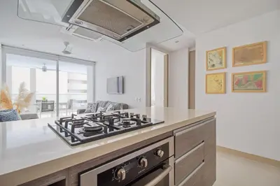 a kitchen with a stove top oven in a room at Descanso y playa, cómodo apartamento en Kuali, Santa Marta in Santa Marta