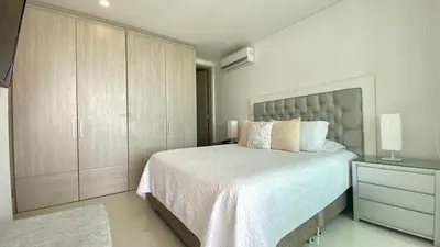 a bedroom with a large white bed and a cabinet at Apartamento de una habitacion Palmetto Sunset 1703 in Cartagena de Indias
