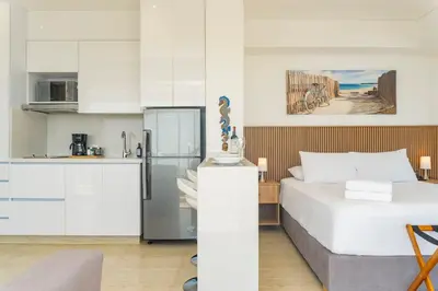 a kitchen and a bedroom with a bed and a refrigerator at Suite esquina con balcón y vista 180° al mar CB1429 in Cartagena de Indias