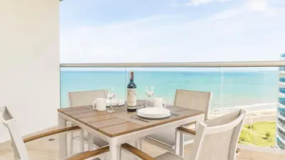 a dining room with a table with a bottle of wine at Suite esquina con balcón y vista 180° al mar CB1429 in Cartagena de Indias