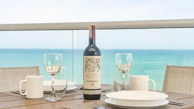 a bottle of wine sitting on a table with glasses at Suite esquina con balcón y vista 180° al mar CB1429 in Cartagena de Indias