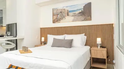 a bedroom with a large white bed and a bathroom at Suite esquina con balcón y vista 180° al mar CB1429 in Cartagena de Indias