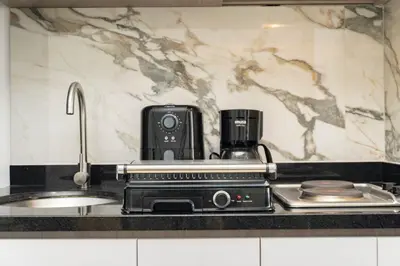 a kitchen counter with a coffee maker next to a sink at Suite moderna con WiFi rápido, balcón y vista CB1432 in Cartagena de Indias