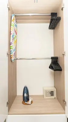 a shelf in a room with a microwave and a clock at Suite moderna con WiFi rápido, balcón y vista CB1432 in Cartagena de Indias