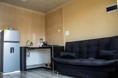 a living room with a black couch and a refrigerator at Charles gomez in Cartagena de Indias