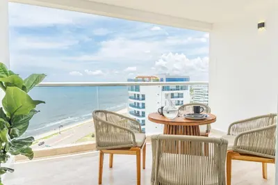 a balcony with a table and chairs and a view of the ocean at CB1526 | Suite tropical piso 15 frente al mar in Cartagena de Indias