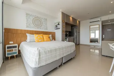 a bedroom with a large bed and a kitchen at CB1531 | Confort premium: cama King y balcón in Cartagena de Indias