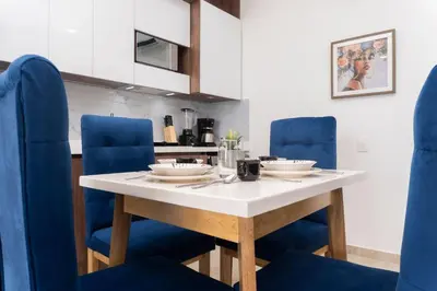 a table with blue chairs and bowls on it at Apartamento ideal para familias y trabajo CB931 in Cartagena de Indias