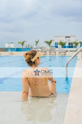 a woman sitting in the water next to a swimming pool at Apartamento ideal para familias y trabajo CB931 in Cartagena de Indias