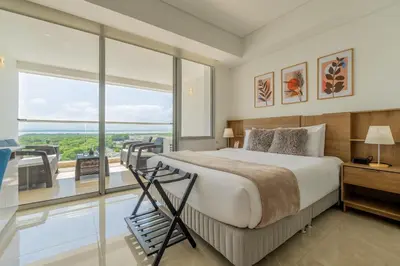 a bedroom with a large bed and a large window at CB937 | Stylish loft piso 9 con balcón y vista ciudad in Cartagena de Indias
