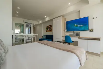 a hotel room with a large bed and a tv at CB937 | Stylish loft piso 9 con balcón y vista ciudad in Cartagena de Indias