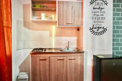 a small kitchen with wooden cabinets and a sink at Apartaestudios la terraza 1 in Sincelejo