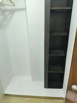 a walk in closet with a white wall and shelves at Apartaestudios la terraza 1 in Sincelejo