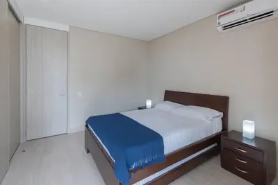 a bedroom with a bed with a blue blanket and a nightstand at 2BD Next to Beach W Pvt Jacuzzi Martinique 74 in Cartagena de Indias