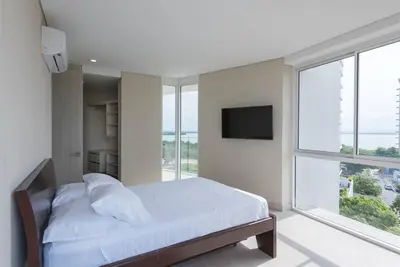 a bedroom with a bed and a large window at 2BD Next to Beach W Pvt Jacuzzi Martinique 74 in Cartagena de Indias