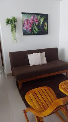a couch in a living room with a table and a chair at Caribe campestre coveñas in Coveñas