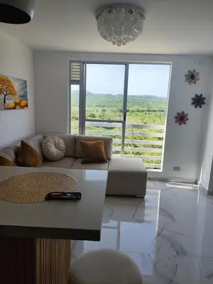 a living room with a couch and a large window at hermoso apto de lujo al norte alypao Deluxe in Barranquilla