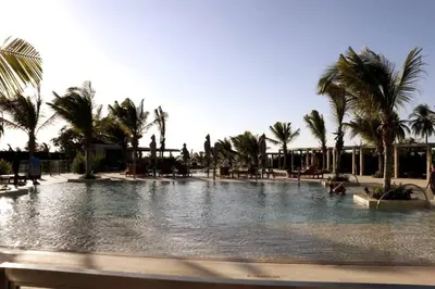 a large pool with palm trees in a resort at Apartamento en la playa mas tranquila de Cartagena in Cartagena de Indias