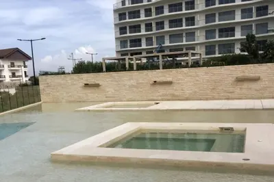 a swimming pool in front of a large building at Apartamento en la playa mas tranquila de Cartagena in Cartagena de Indias