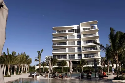 a large apartment building next to a swimming pool at Apartamento en la playa mas tranquila de Cartagena in Cartagena de Indias