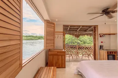 a bedroom with a bed and a view of the water at Islawa Soy Local - Isla Privada in Baru