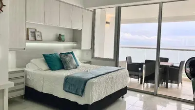 a bedroom with a bed and a view of the ocean at Suite frente al mar + piscina + balcón privado 727 in Cartagena de Indias