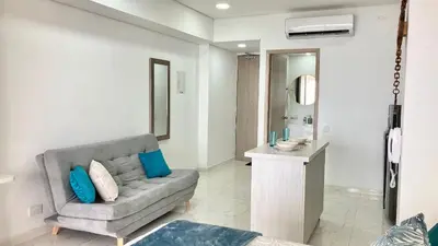 a living room with a couch and a mirror at Suite frente al mar + piscina + balcón privado 727 in Cartagena de Indias