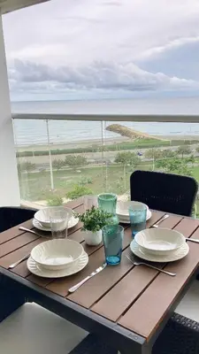 a wooden table with a view of the ocean at Suite frente al mar + piscina + balcón privado 727 in Cartagena de Indias