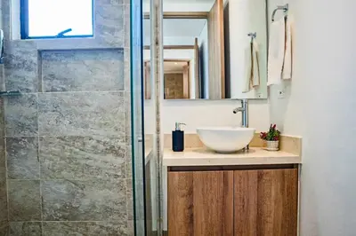 a bathroom with a sink and a glass shower at Dizztravel Apart Murano Centro Exclusivo apto 2701 in Cartagena de Indias