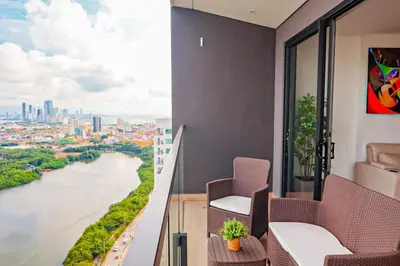 a balcony with chairs and a view of a river at Dizztravel Apart Murano Centro Exclusivo apto 2701 in Cartagena de Indias
