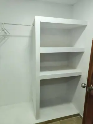 a closet with white shelves in a room at Apartaestudios la terraza 2 in Sincelejo