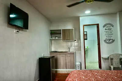 a room with a bed and a kitchen with a mirror at Apartaestudios la terraza 2 in Sincelejo