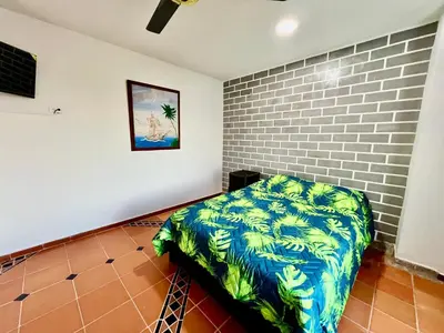 a bedroom with a bed in a room with a brick wall at Apartaestudios la terraza 3 in Sincelejo