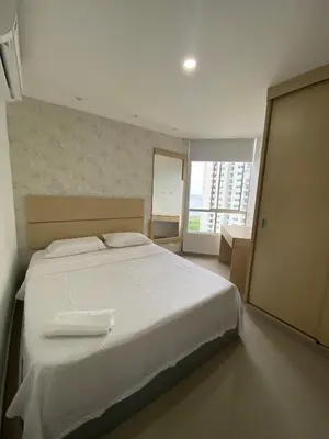 a bedroom with a white bed and a large window at Apto para vacaciones en familia in Cartagena de Indias