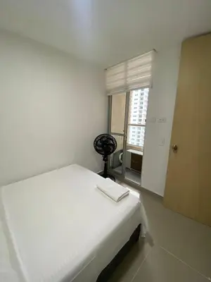 a white bedroom with a bed and a window at Apto para vacaciones en familia in Cartagena de Indias
