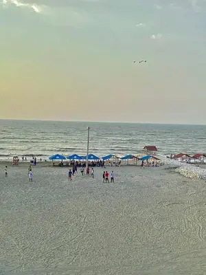 a group of people on a beach with blue umbrellas at Habitación luxury villa oti in Ciénaga