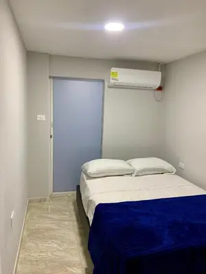 a small bedroom with a bed with a blue blanket at Habitación luxury villa oti in Ciénaga