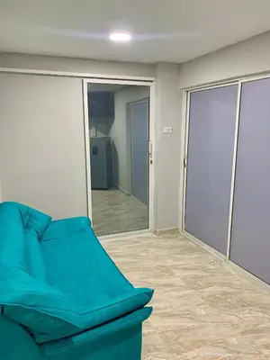 a blue couch in a room with a mirror at Habitación luxury villa oti in Ciénaga